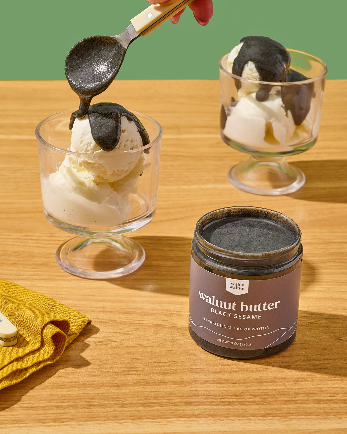 Two glass dessert cups filled with vanilla ice cream and drizzled with our black sesame walnut butter. 